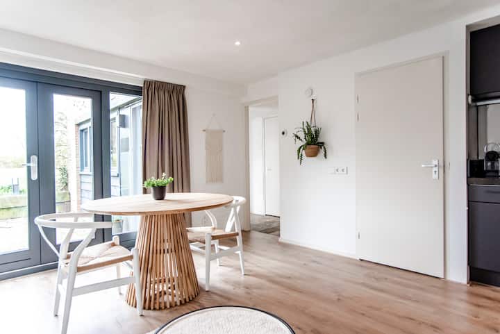 Dining area with round wooden table and garden view